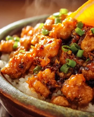 A plate of ground orange chicken served with rice and vegetables.