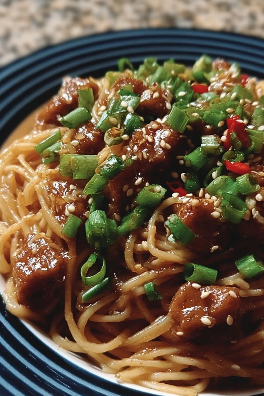 Delicious vegan garlic noodles topped with green onions and sesame seeds