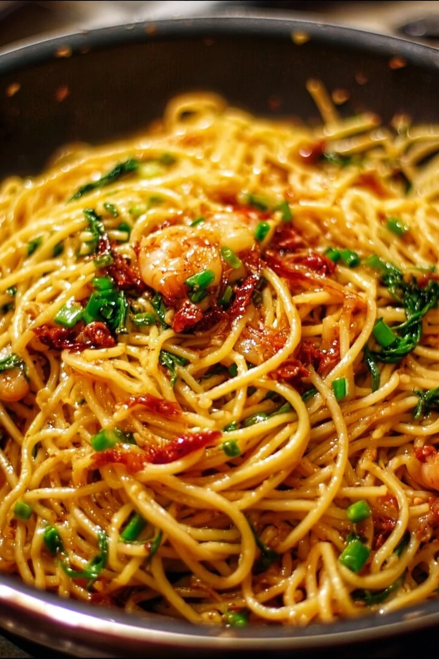 Plate of delicious garlic noodles topped with herbs and garlic.