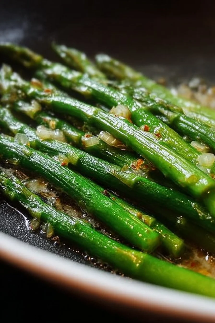 Plate of perfectly sautéed asparagus with garlic and lemon.