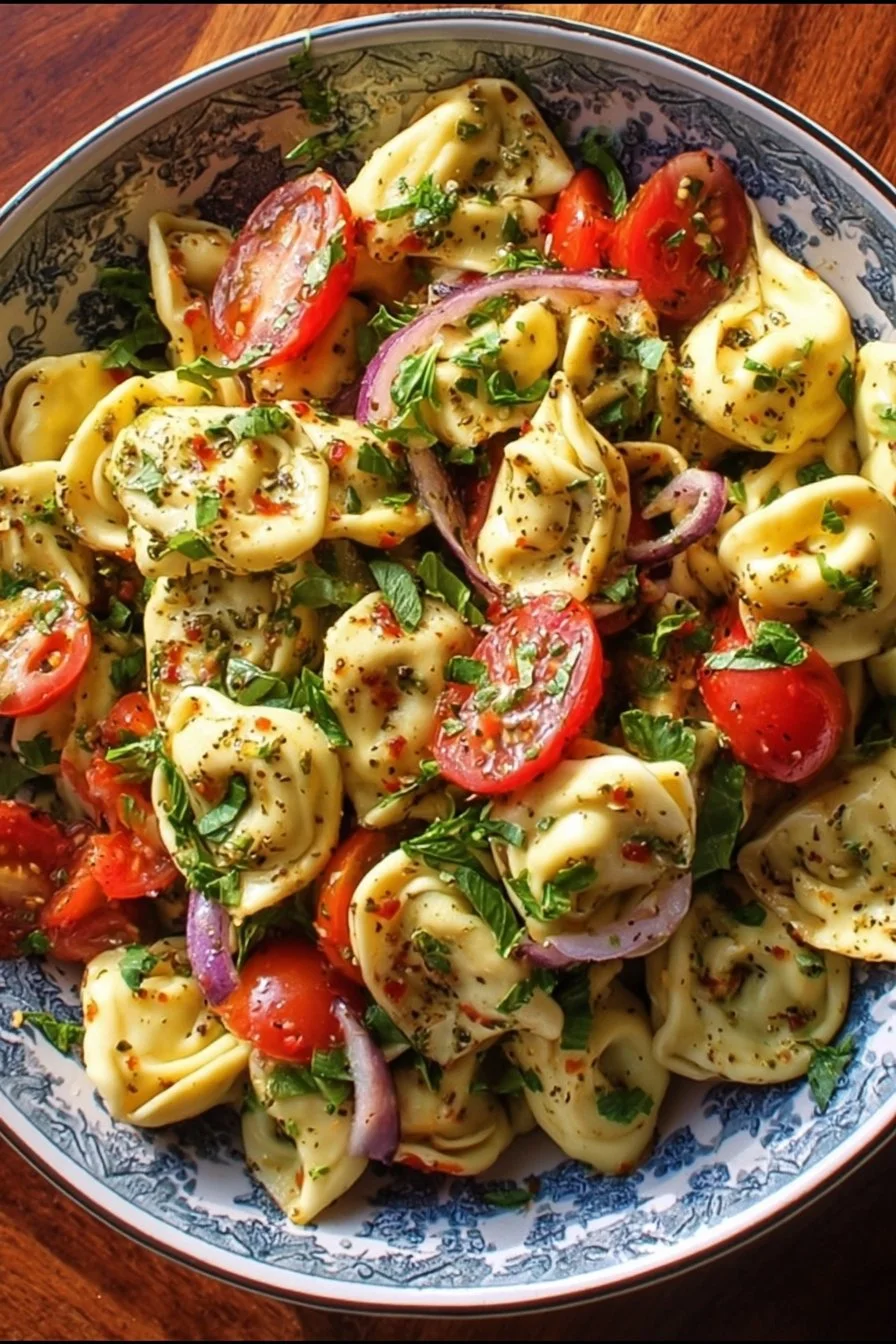 Bowl of easy Tortellini Pasta Salad with colorful vegetables and dressing