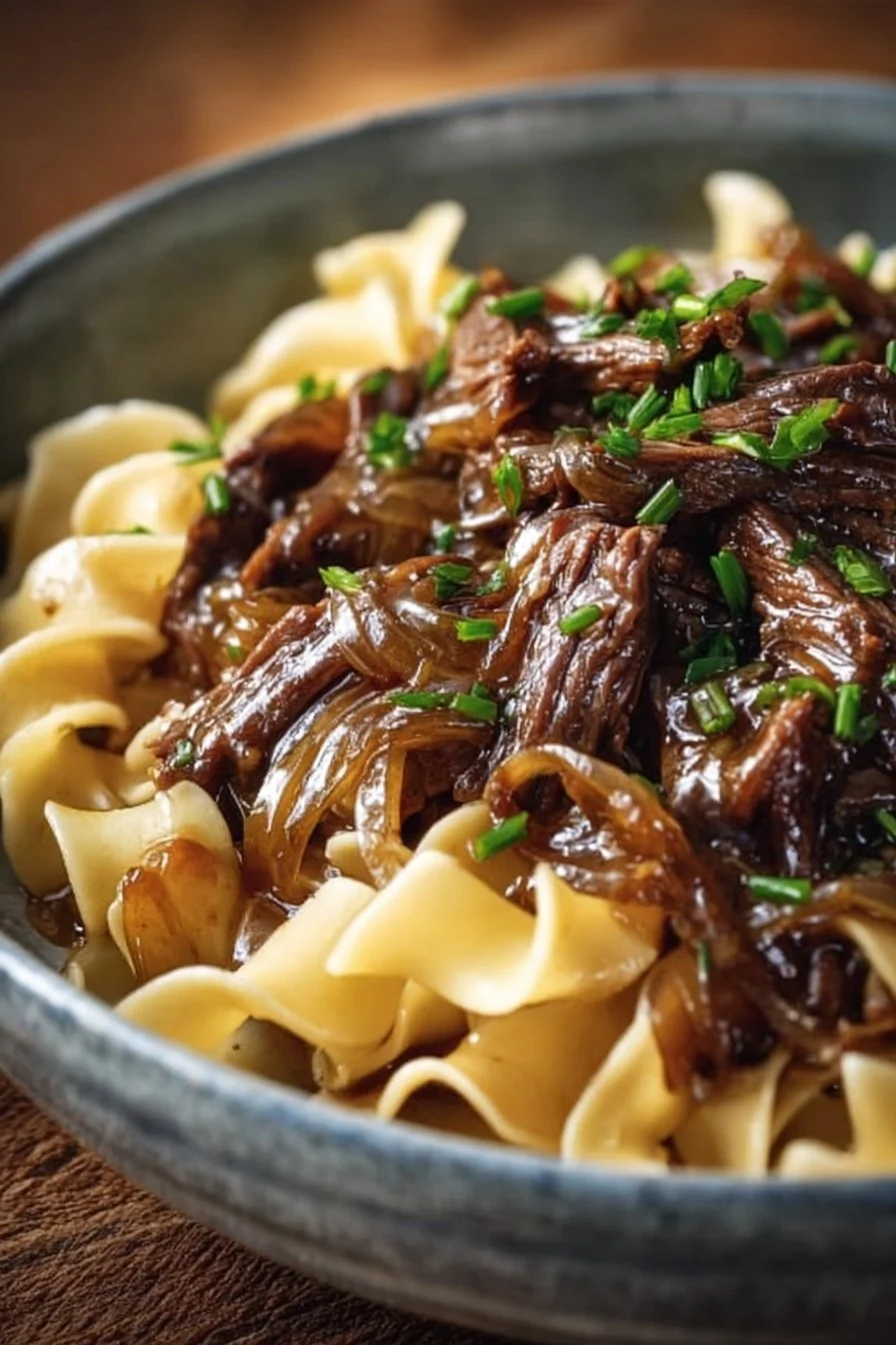 Delicious Sizzling French Onion Beef and Noodles dish garnished with herbs