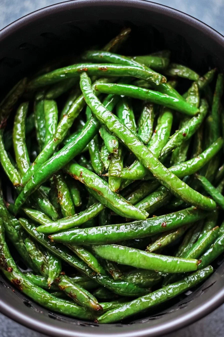 Crispy air fryer green beans served in a bowl, garnished with seasonings.