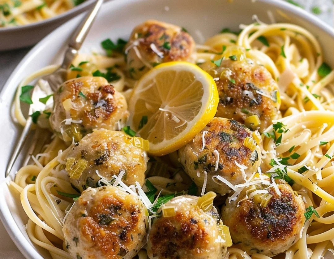 Chicken Piccata Meatballs served with lemon and capers on a plate.