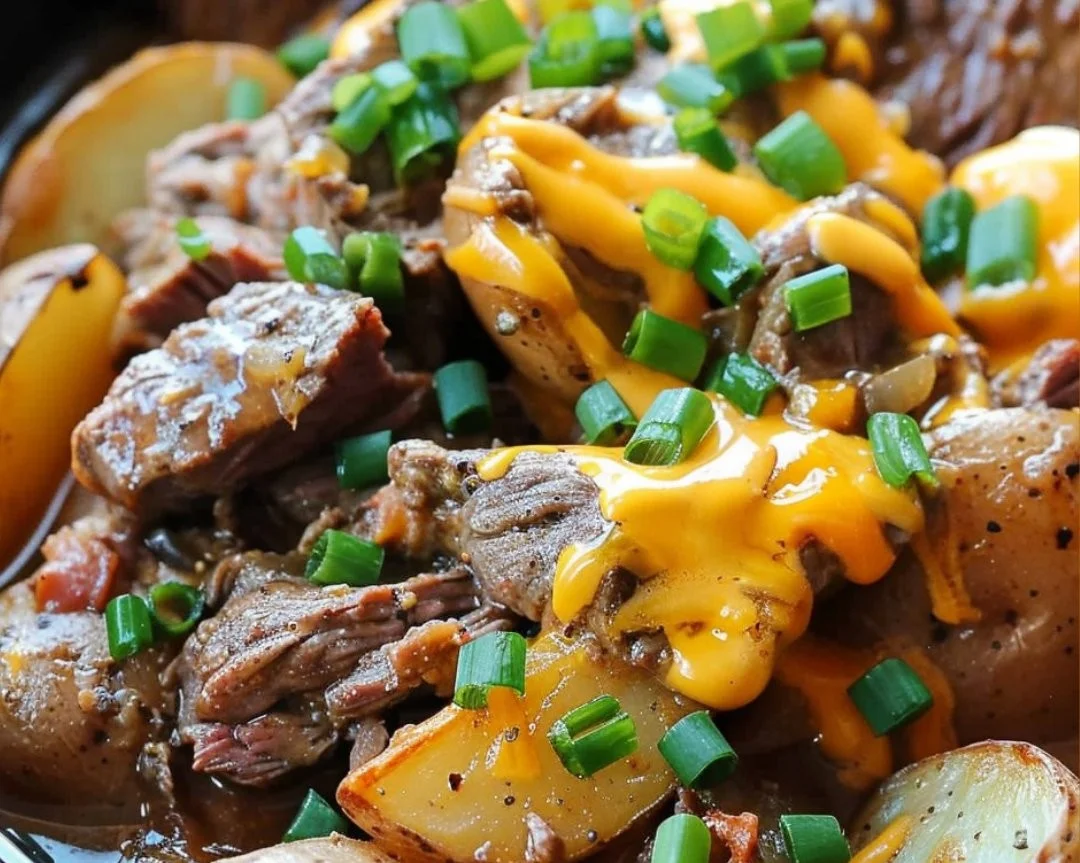 Crockpot Loaded Steak and Potato Bake served in a bowl with herbs on top.