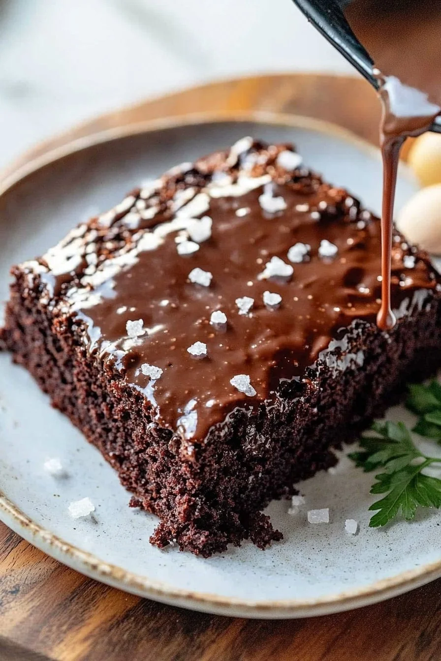 A delicious slice of moist Texas Sheet Cake topped with chocolate frosting.